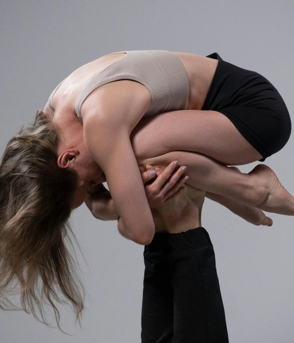 Man performing a warrior yoga pose in a sunlit studio